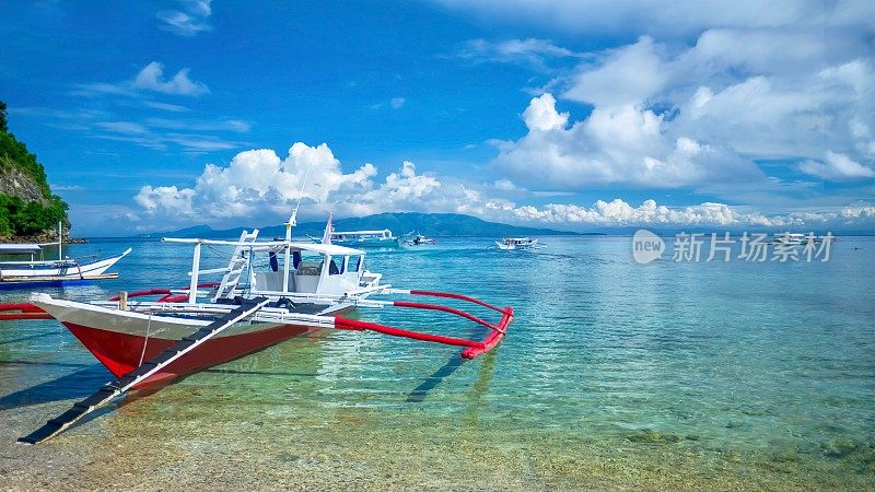 在菲律宾民多洛岛度假小镇加莱拉港(Puerto Galera)碧绿的浅水中，传统的菲律宾木船在当地被称为“班卡”(banca)。